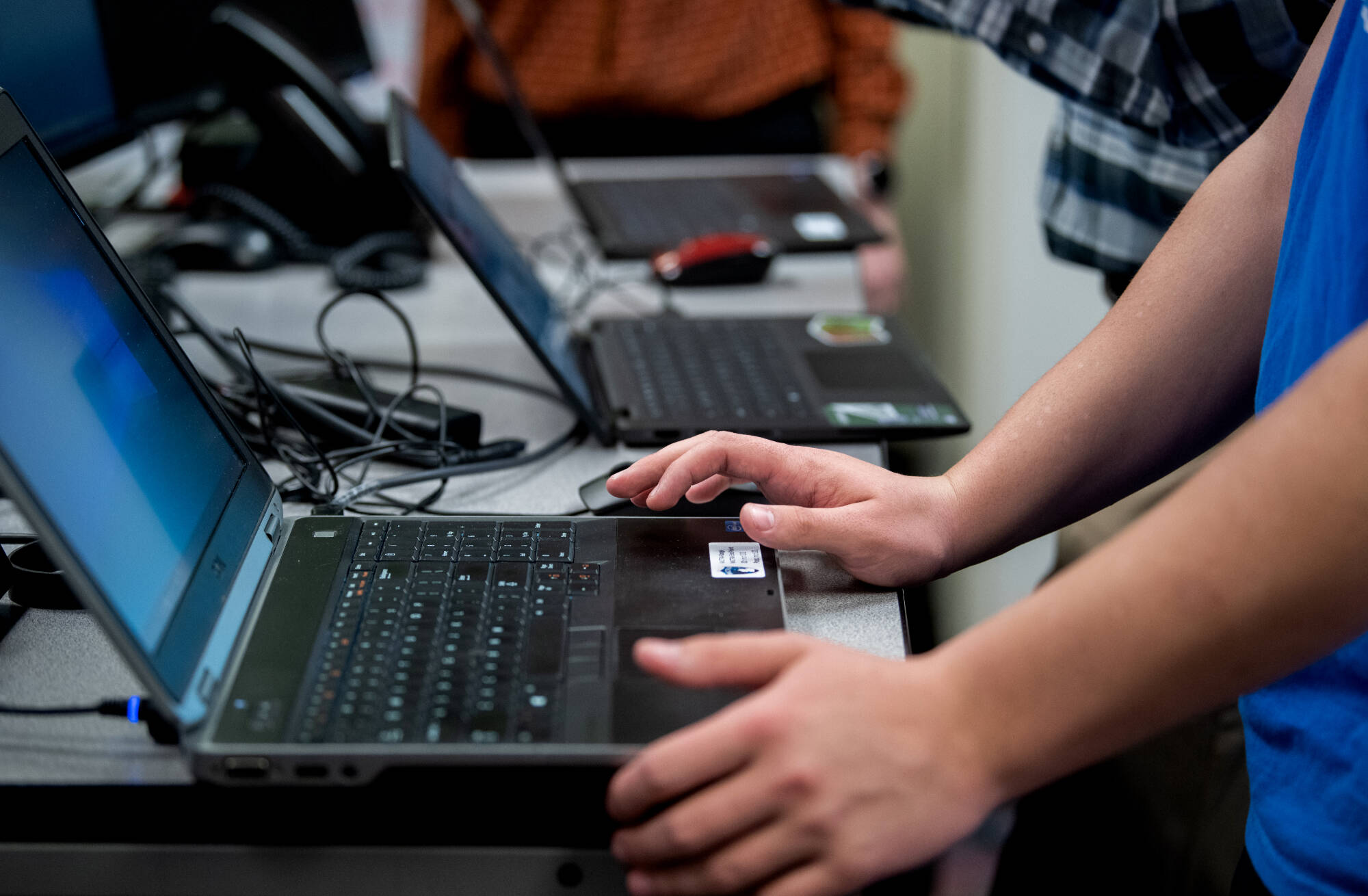 A set of hands coding on a laptop.